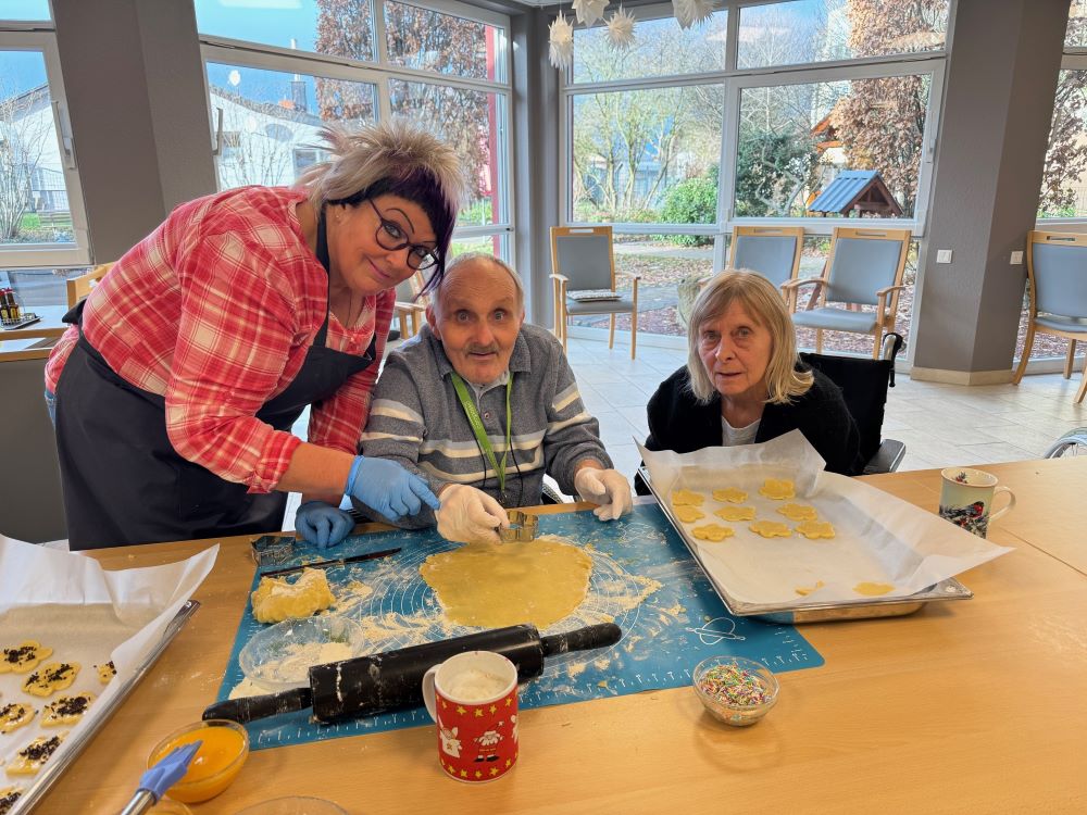Bewohner und Schüler beim gemeinsamen Backen in der Weihnachtsbäckerei des Haus Antonius